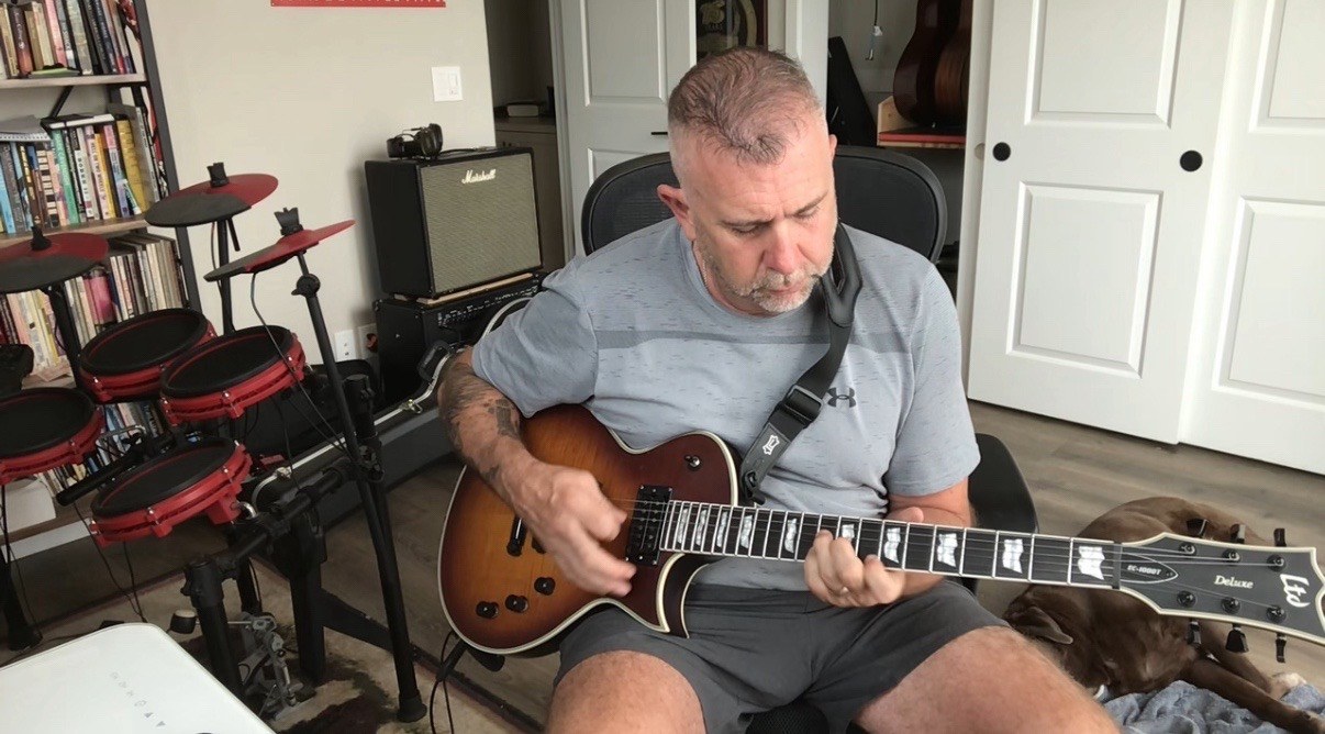 Builder playing guitar to test tone and feel